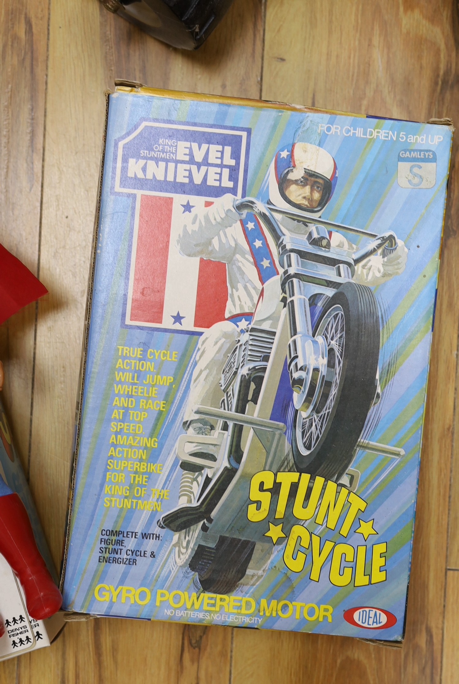 A Denys Fisher Superman, rare in original box, another unboxed, a Unigate milk float with bottles, and a boxed Evel Knievel Stunt Cycle